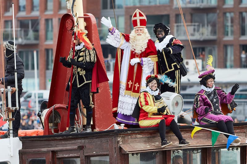 Sinterklaas (۵ دسامبر): بابانوئل هلندی با کشتی از اسپانیا می‌آید! همراه دستیارش Zwarte Piet (امروزه به Roetveegpiet تغییر نام داده).